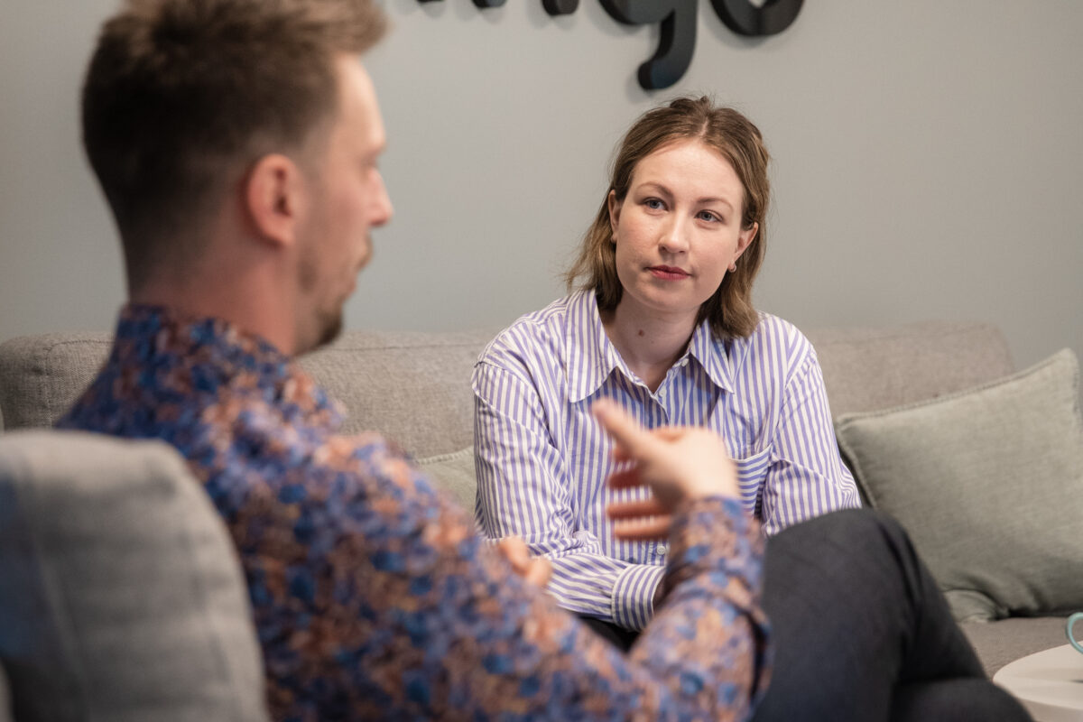 Två personer samtalar. De sitter i en varsin fåtölj snett vridna mot varandra, vilket är bra när man ska ge negativ feedback.