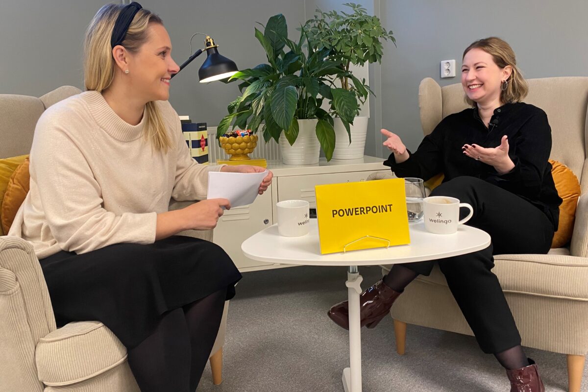 Två personer sitter i varsin fåtölj. En skylt på bordet visar att de pratar om PowerPoint.